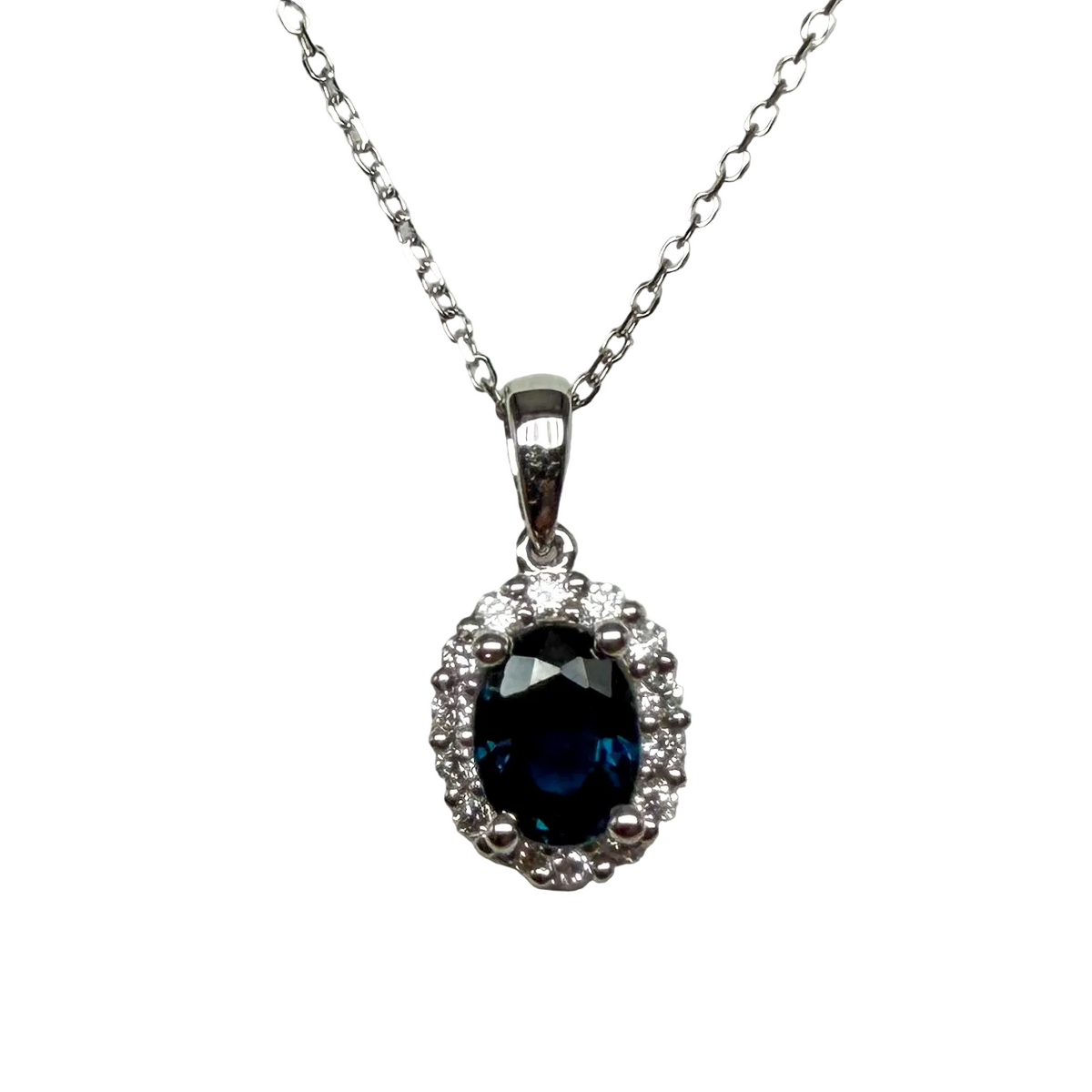 Oval blue sapphire pendant necklace with diamond halo on white gold chain